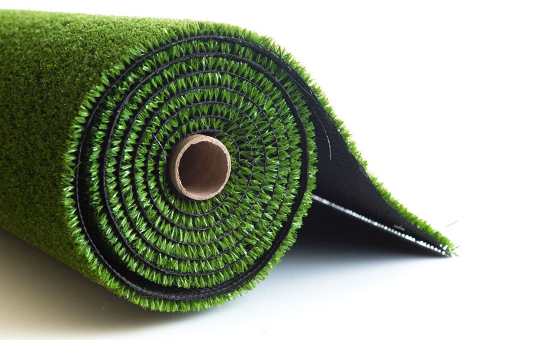 Artificial grass roll cross-section showing tufted pile and black backing layers