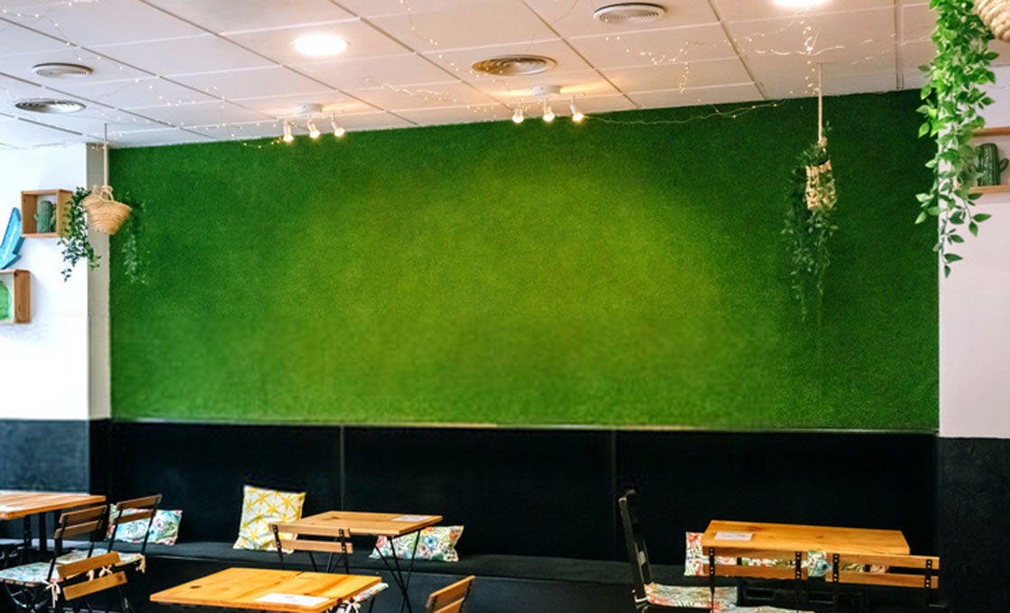 Artificial grass wall panel close-up showing fiber texture and grid backing
