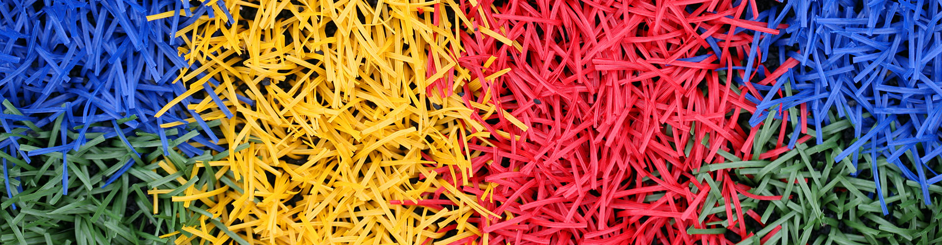 Fibras de césped artificial coloreadas que muestran un vibrante acolchado bicolor
