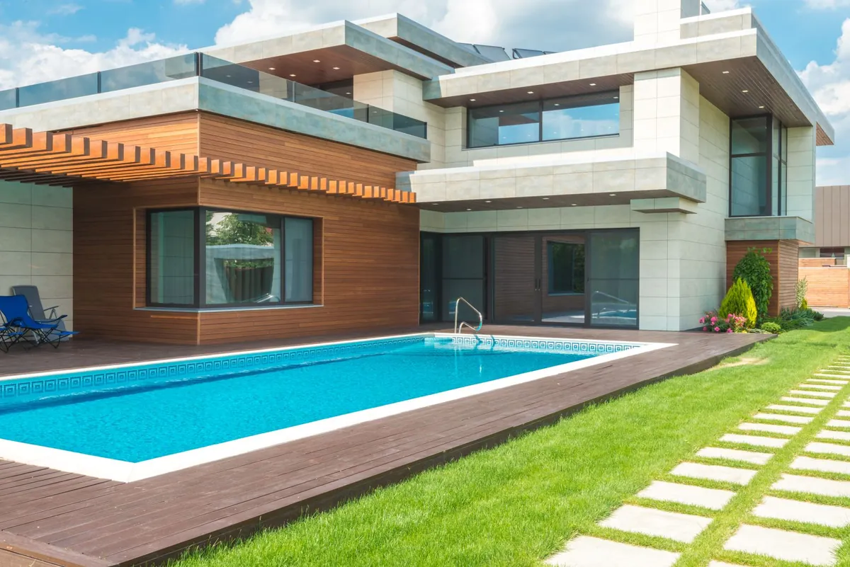 A swimming pool bordered by a green garden lawn