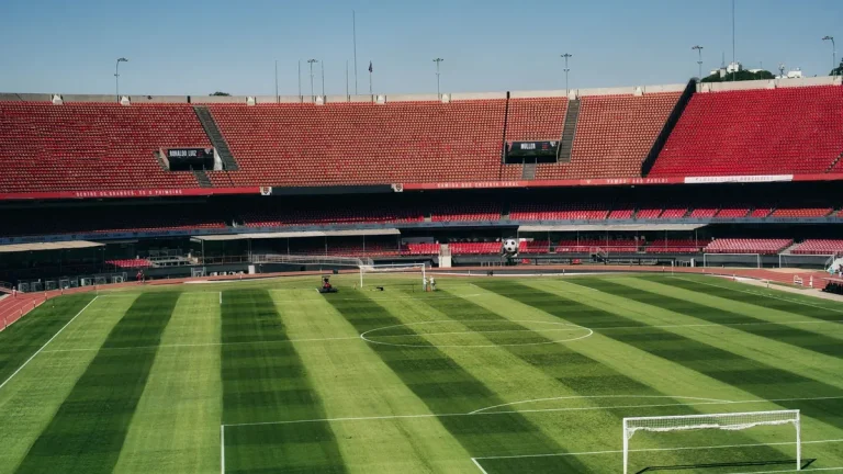 Aerial view of an empty soccer stadium with a vibrant green field ready for a match.