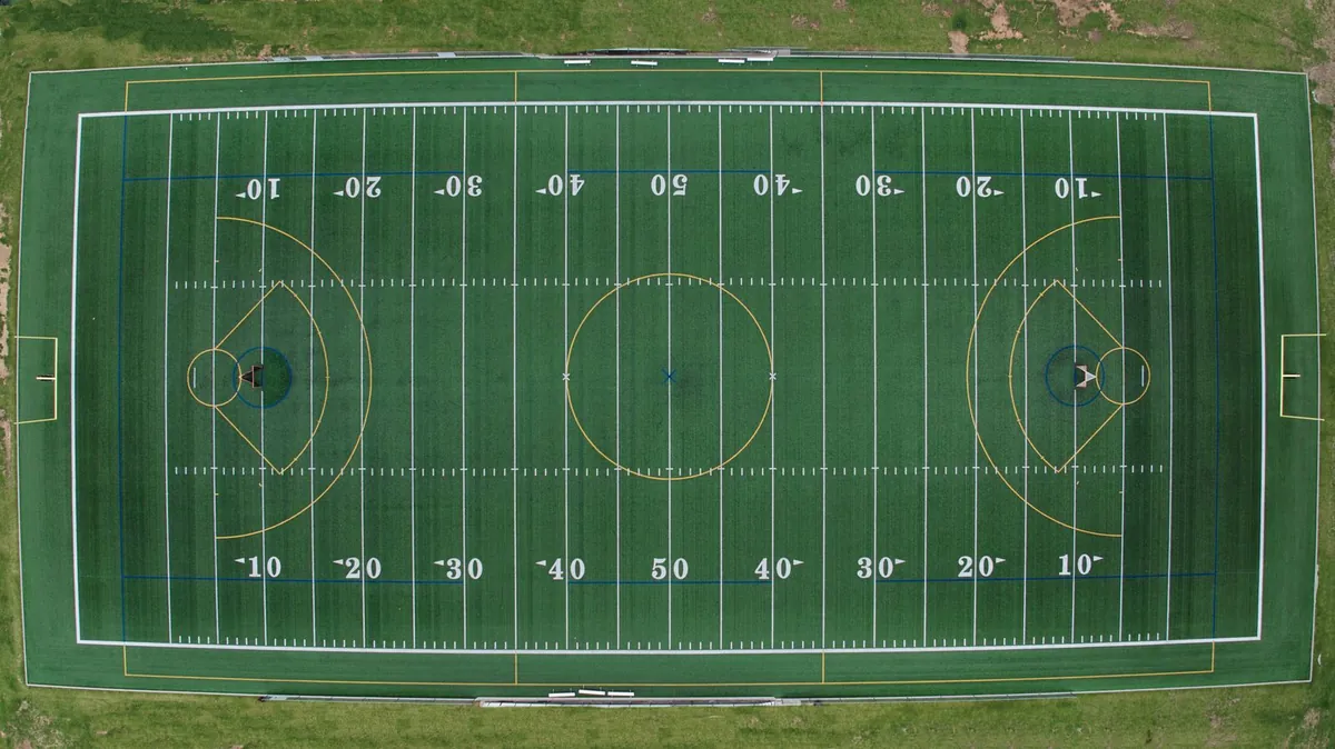 Green artificial turf field carrying several sets of coloured line markings