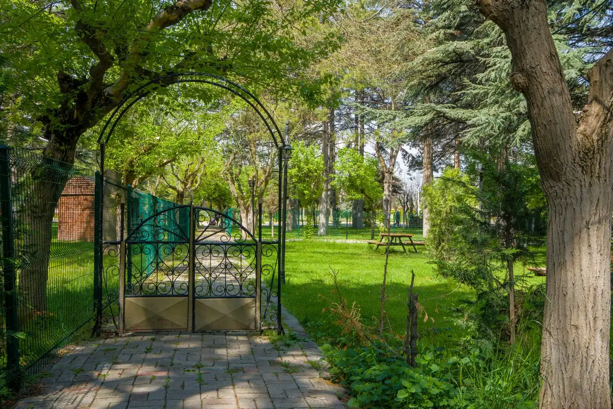 Worn path across artificial grass leading to a garden gate