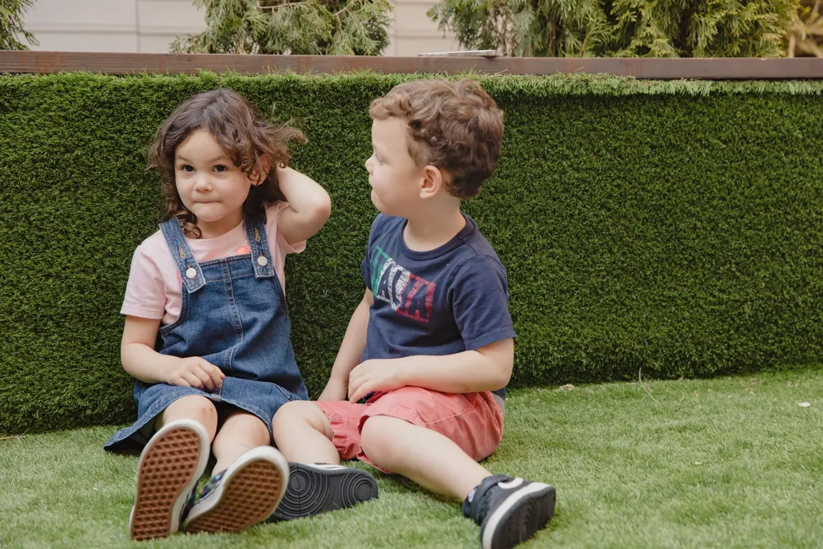 Family lawn laid in artificial grass beside a herbaceous border in a residential garden