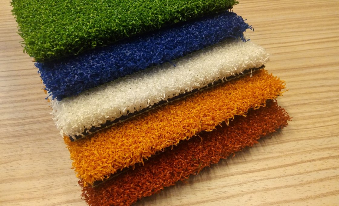 Multicolored artificial grass sample swatches arranged on a table