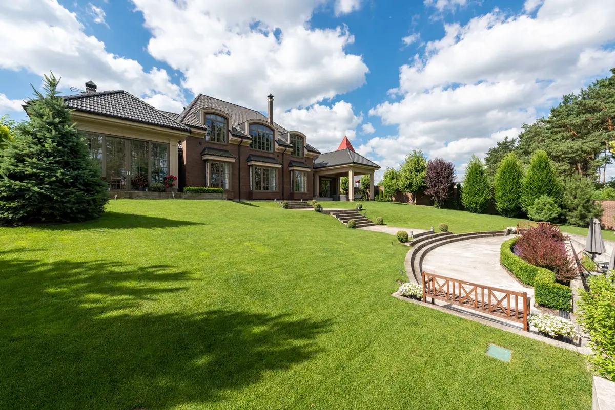 Elegant brick mansion with manicured lawn