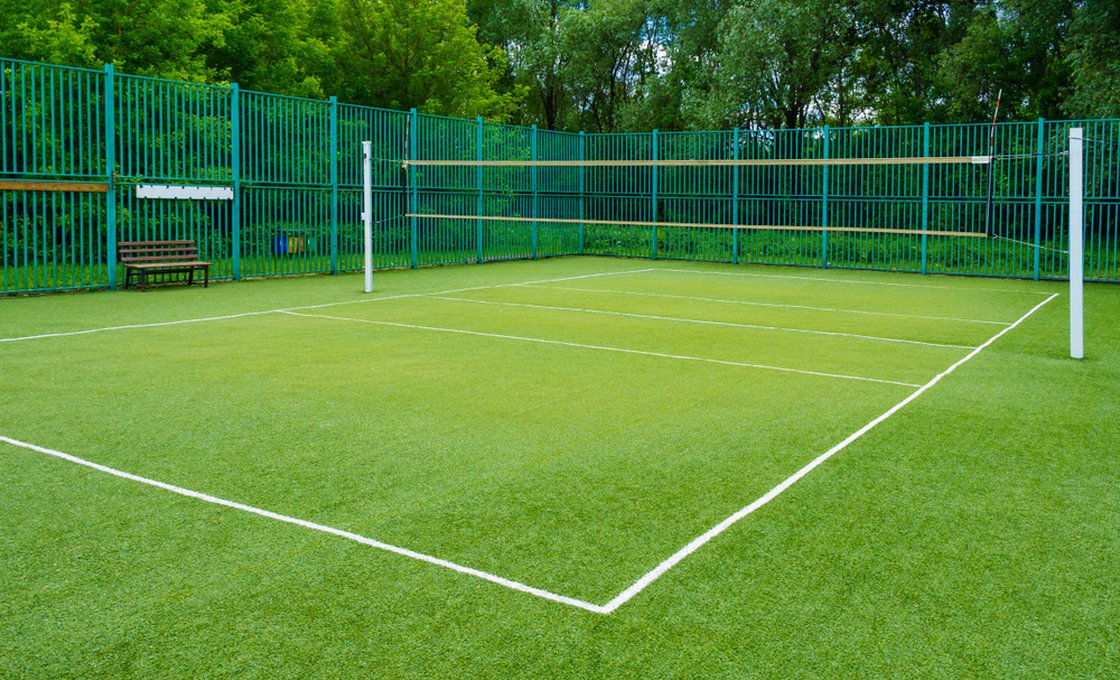 Outdoor multi-sport court with artificial grass and perimeter fencing