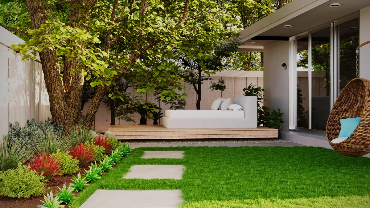 Artificial lawn with stepping stones and planted beds in a courtyard