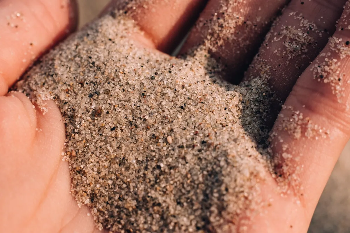 Washed silica sand held in a hand, a common artificial turf infill material