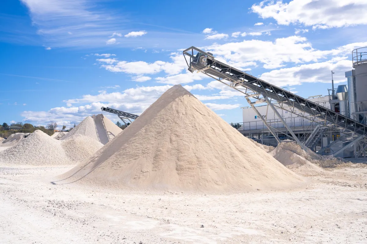 Quarry scene with conveyor belt and large sand piles