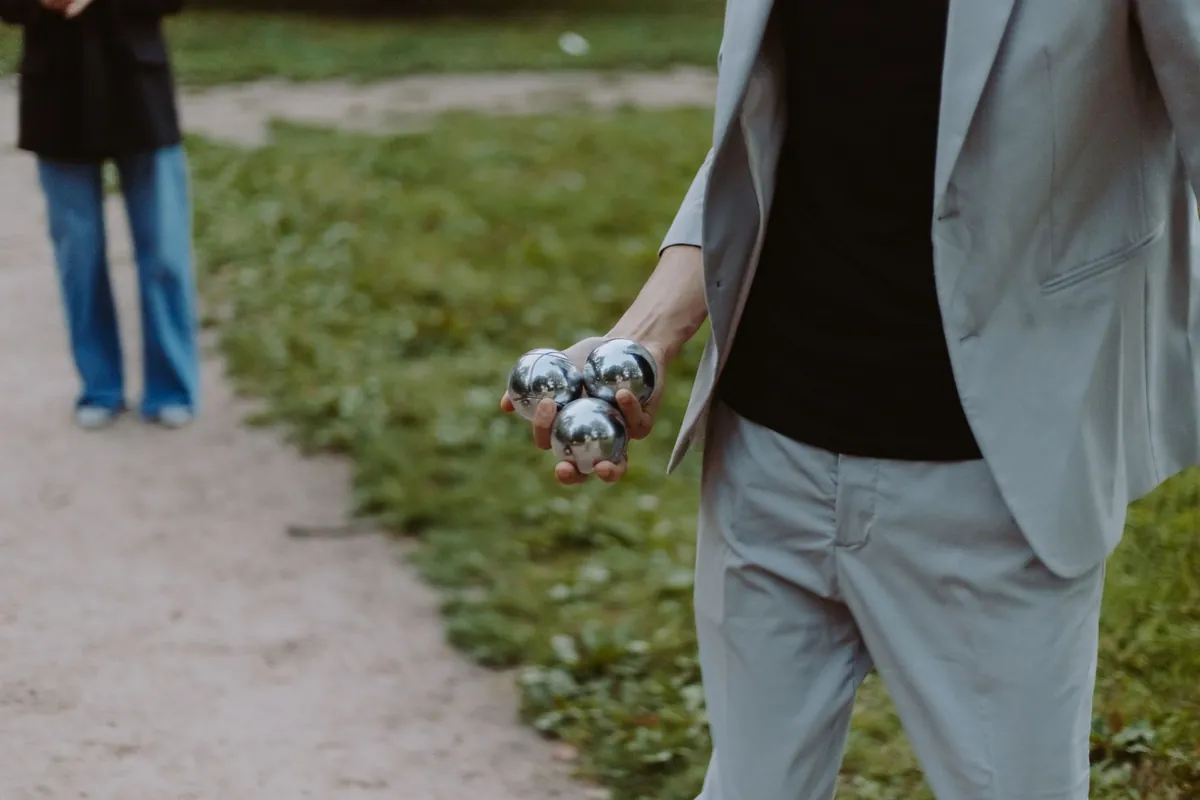 Holding a bocce ball over the court surface