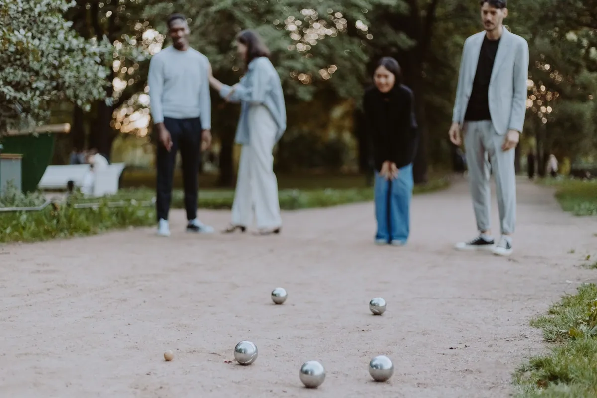 Friends playing a game of bocce in a park