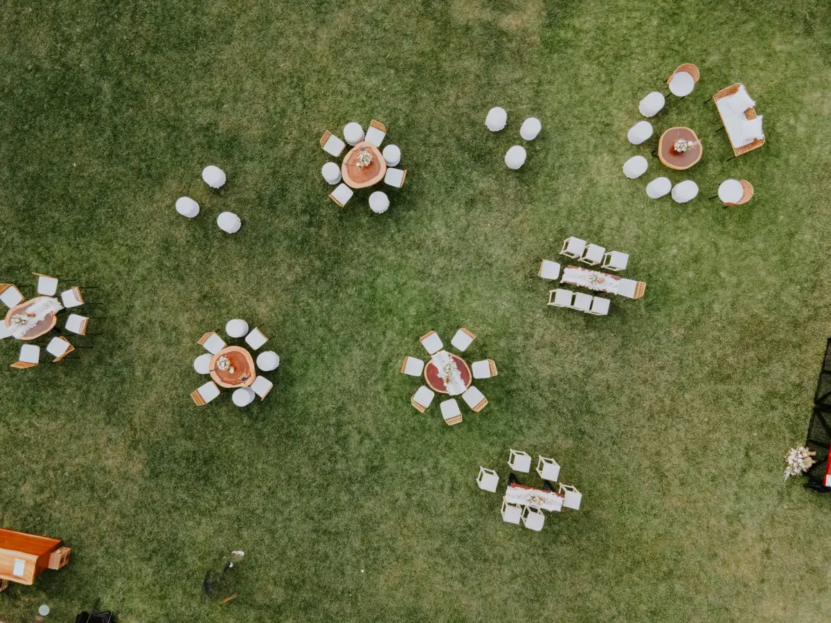 Outdoor event tables and chairs arranged on a green turf surface