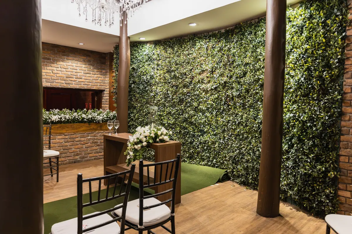 Indoor venue with brick walls, florals and greenery