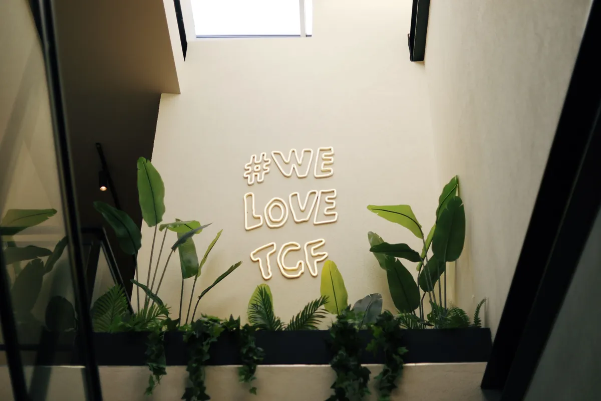 Stylish interior with neon sign amid lush green wall