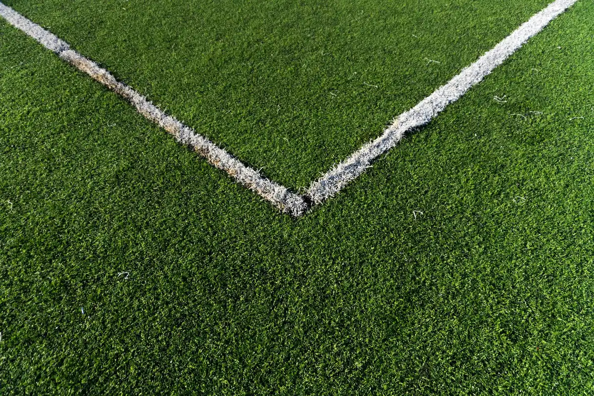 Crisp artificial turf seen from above with white corner lines