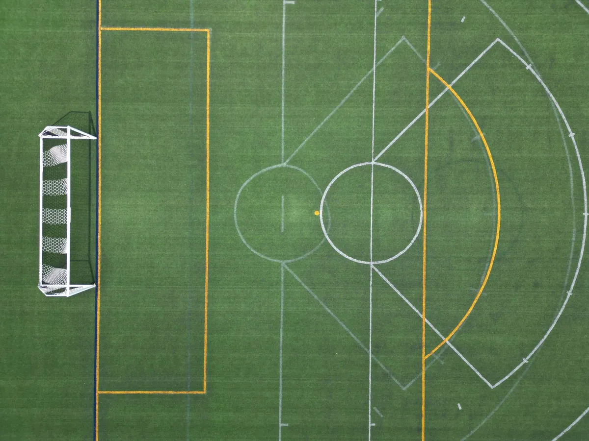 Green artificial turf field seen from above in daylight