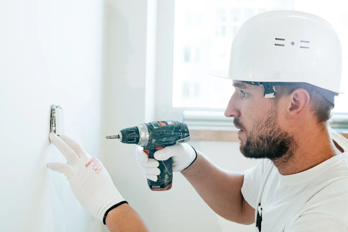 Construction worker using a drill on a wall
