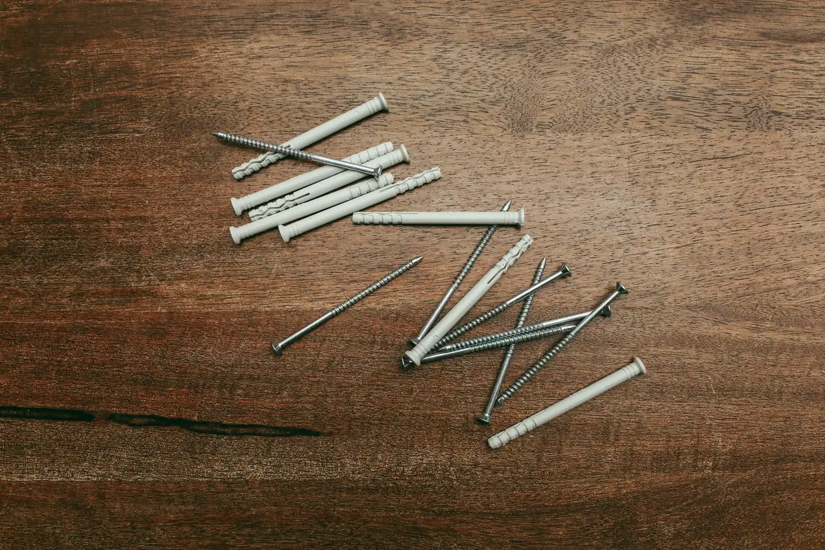 Screws and nylon anchors laid out on a workbench
