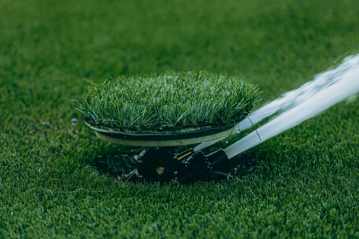 Sprinkler watering a lush green lawn evenly