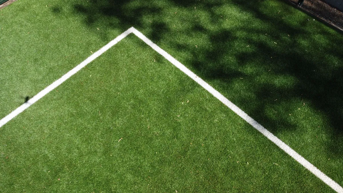 Aerial view of an artificial turf sports field with white line markings