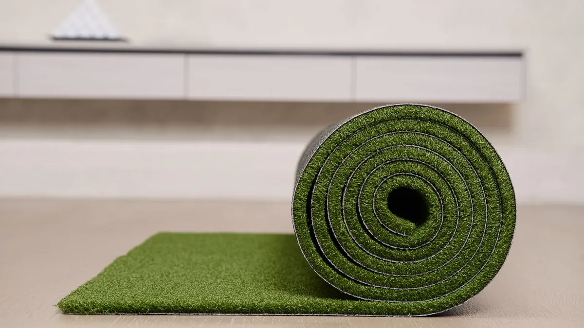 A turf mat laid flat beside a standing roll