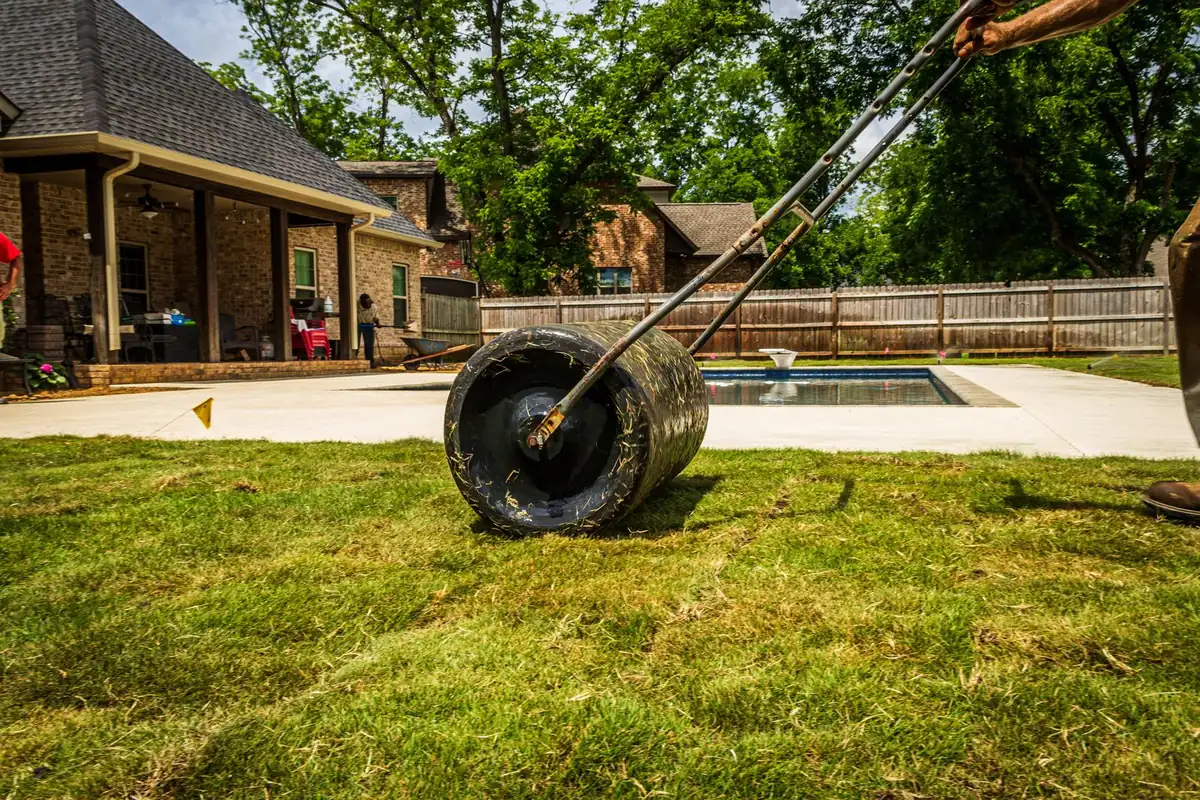Suburban backyard where artificial turf is being rolled out in straight sections