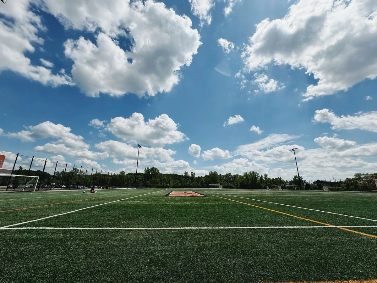 Green turf field under an open blue sky