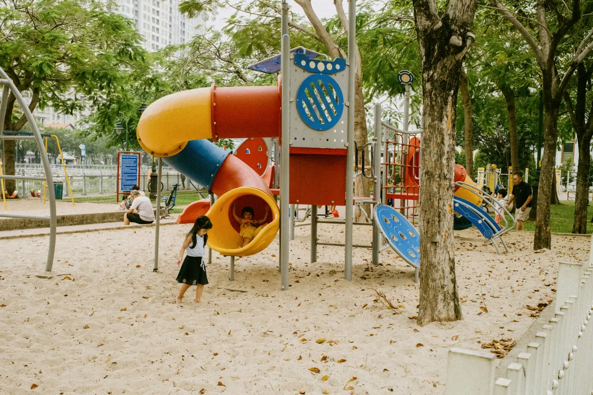 Kids enjoying colorful slides at an outdoor playground