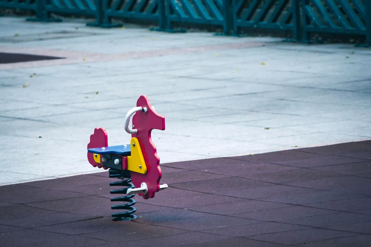Spring-mounted playground toy on a resilient surface