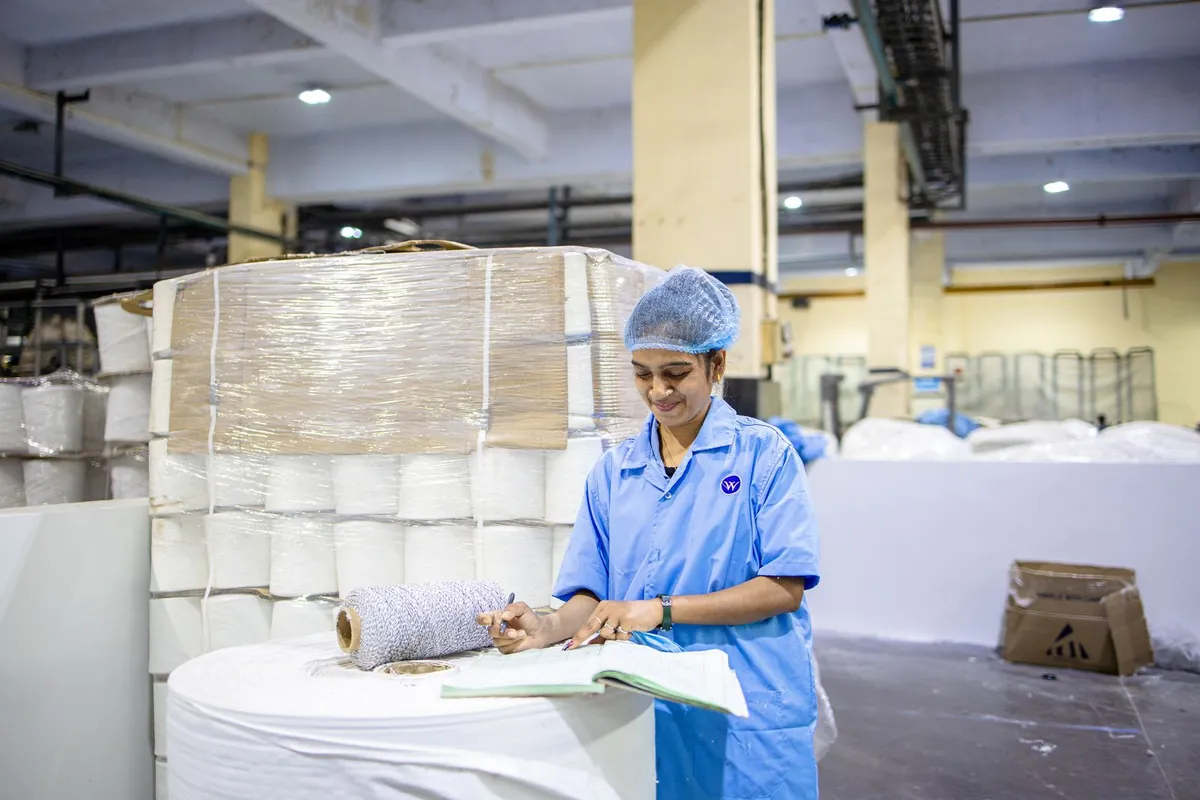 Factory worker recording quality control details in production