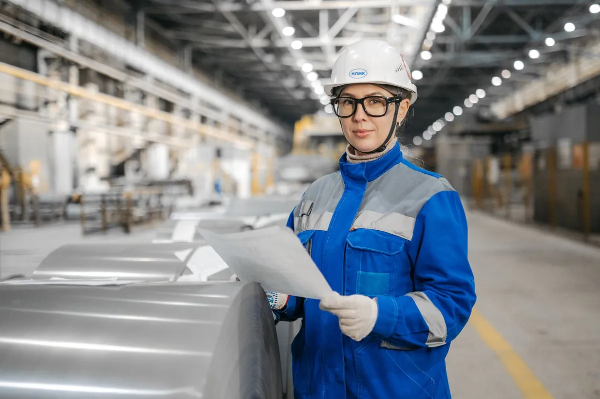 Engineer in safety gear inspecting machinery in a facility