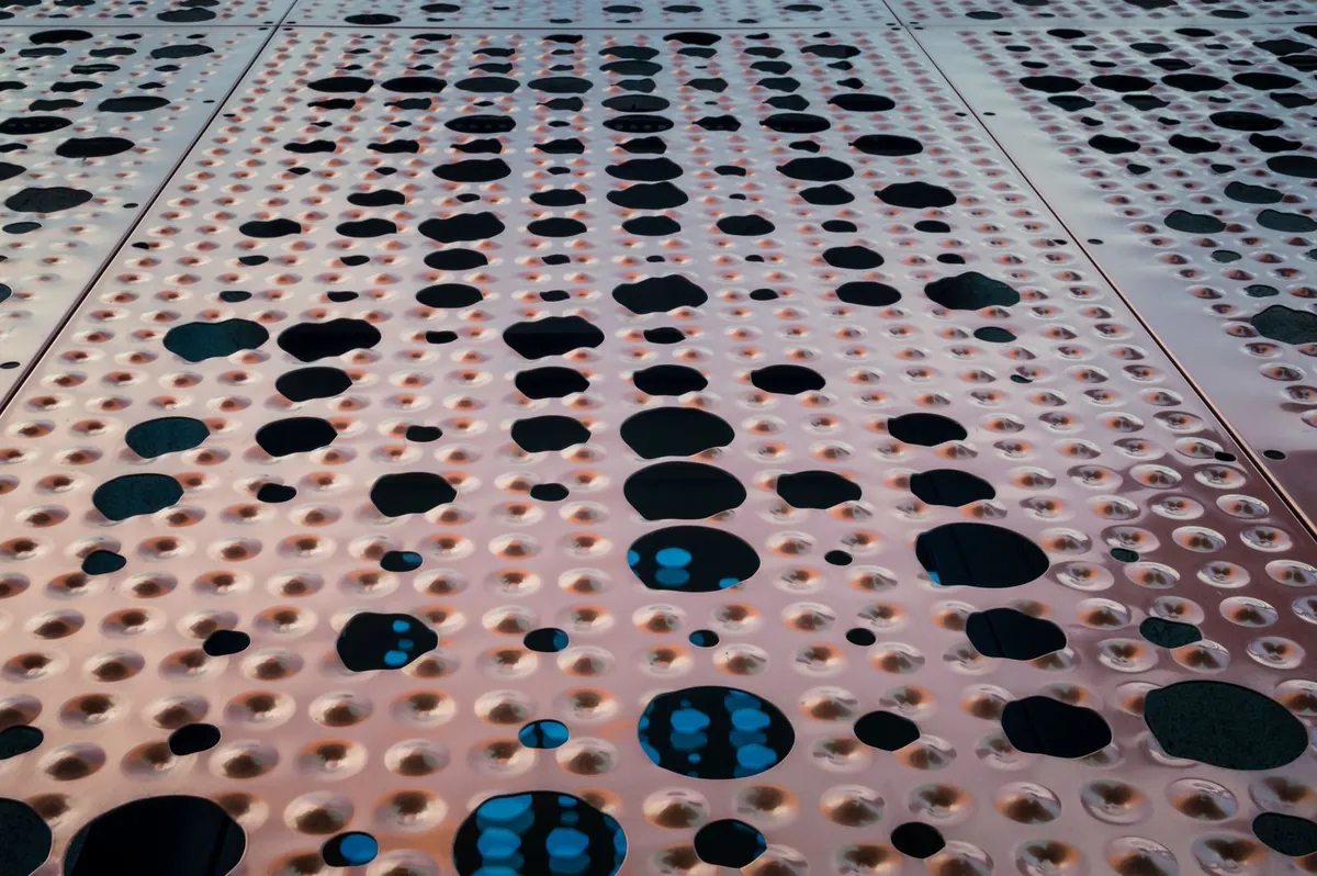 Abstract close-up of a perforated surface with regular openings