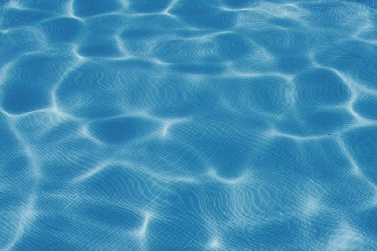 Blue swimming pool water surface in sunlight