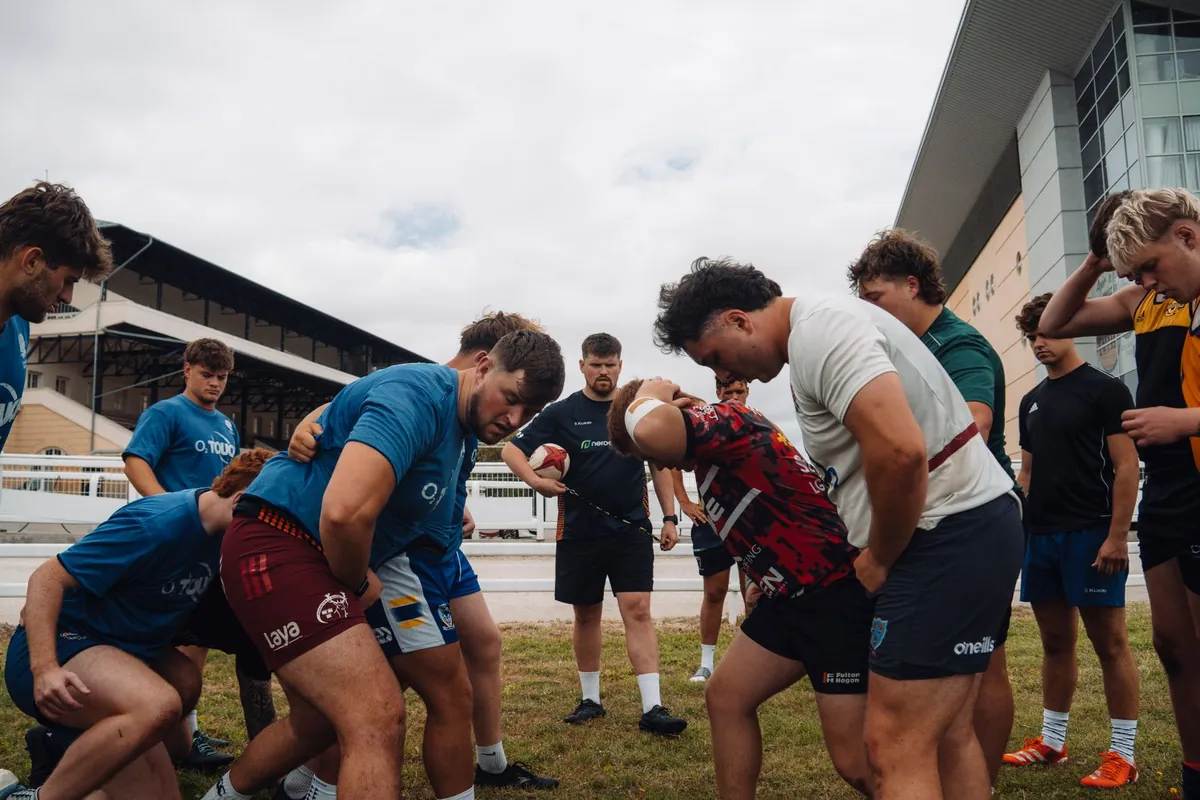 Rugby team practicing scrum alignment on an outdoor field