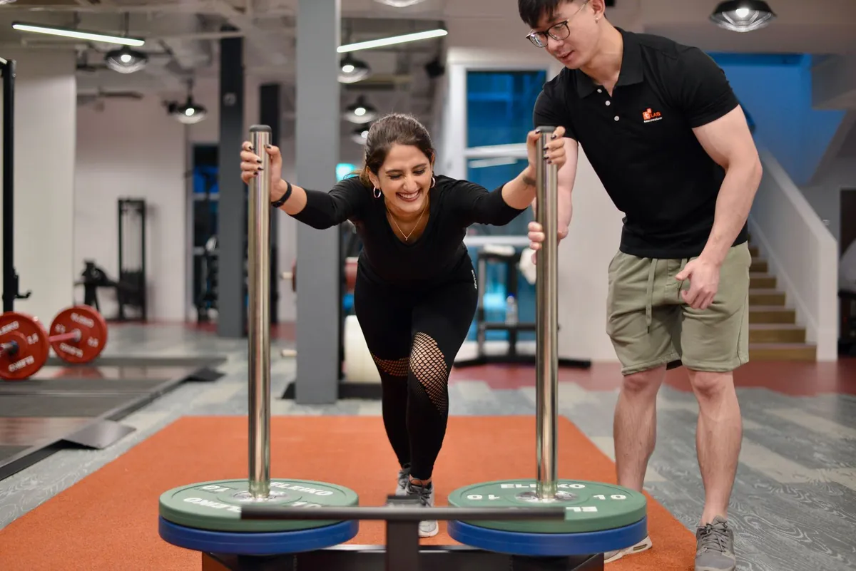 Athlete pushing a prowler sled in a gym