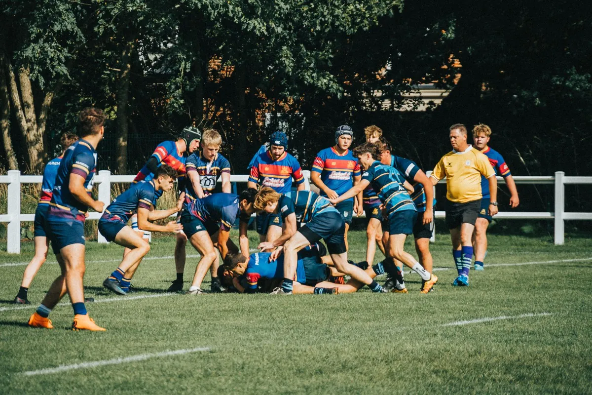Rugby players in a dynamic game on a sunny outdoor field