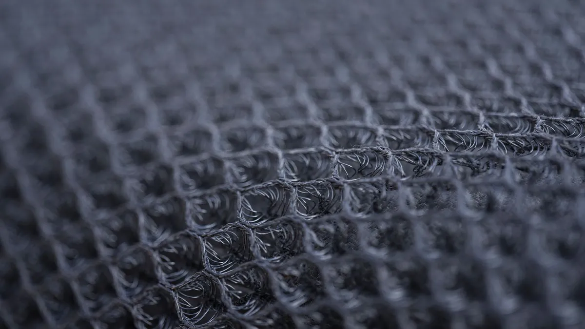 Close view of a dark mesh layer with an open grid structure