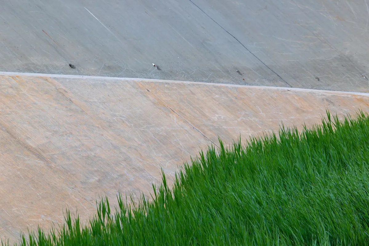 Green grass beside a geometric concrete wall