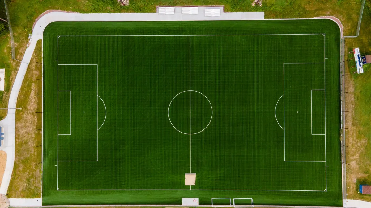 A pitch from above with centre and penalty markings