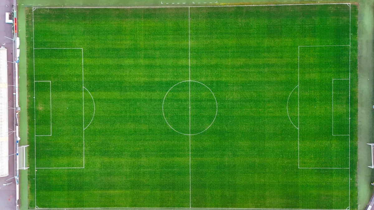 Aerial view of a full-size marked pitch with an even striped surface