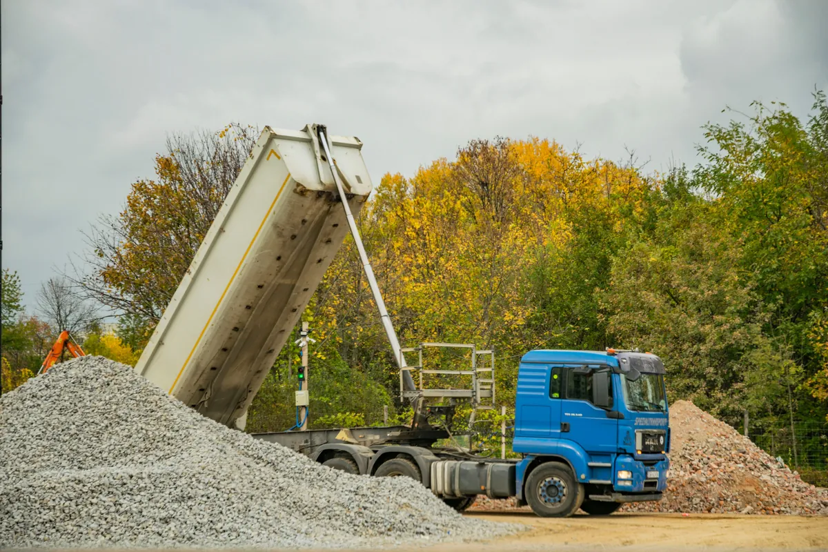 Dump truck unloading gravel at a construction site